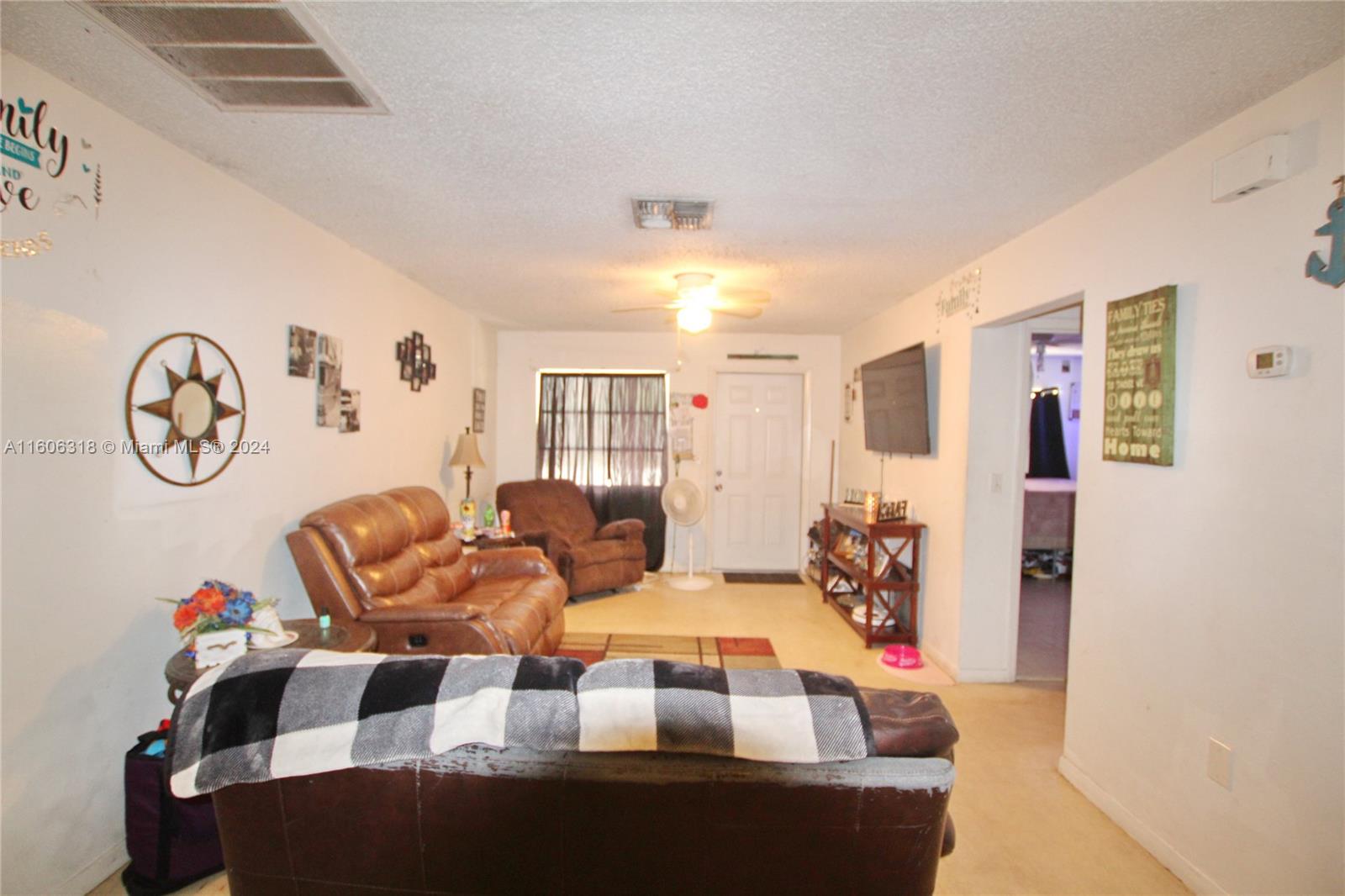1401 Bassage Road Sebring, FL 33875 - Photo 12 of 18 a living room with furniture a table and paintings on the wall