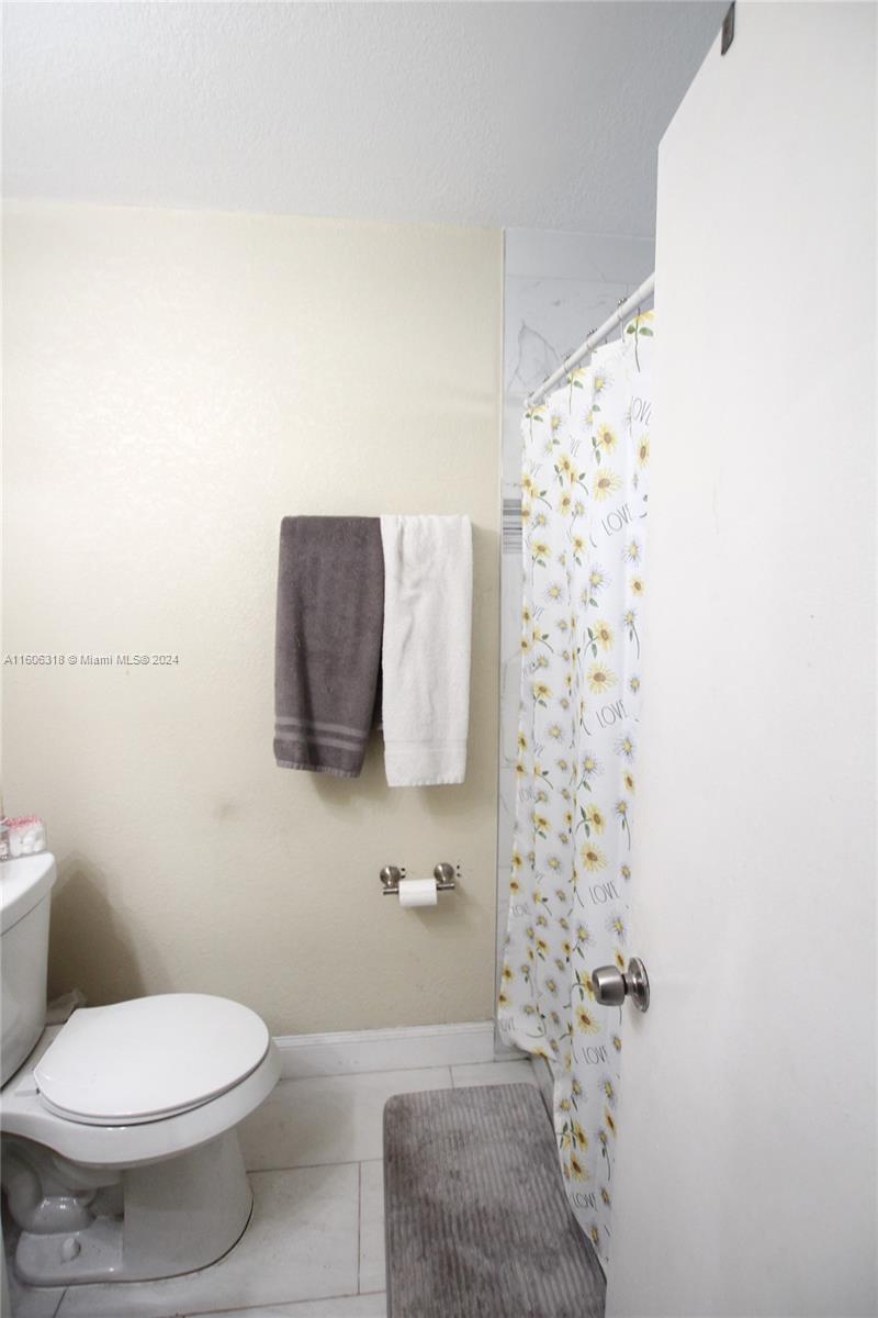 1401 Bassage Road Sebring, FL 33875 - Photo 14 of 18 a white toilet sitting next to a shower curtain