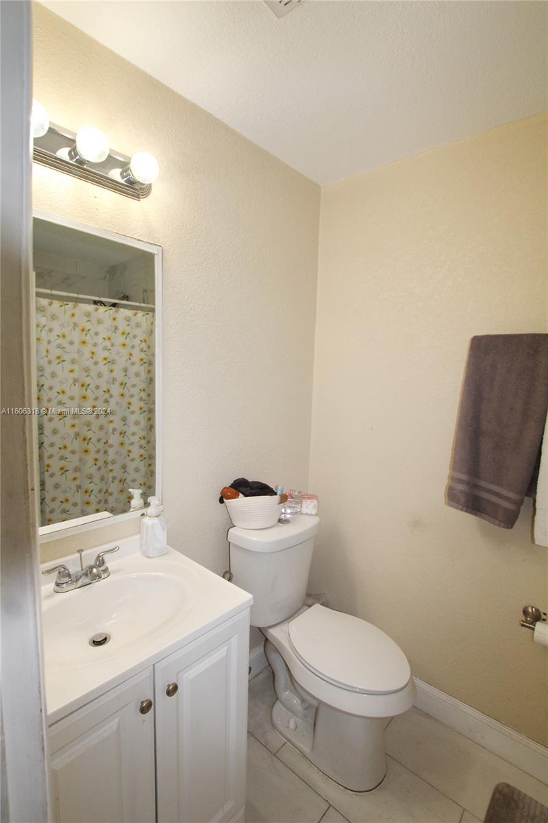 1401 Bassage Road Sebring, FL 33875 - Photo 15 of 18 a bathroom with a toilet a sink and a mirror