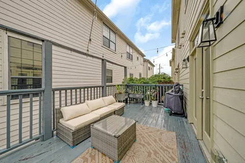 a balcony with furniture and a wooden floor