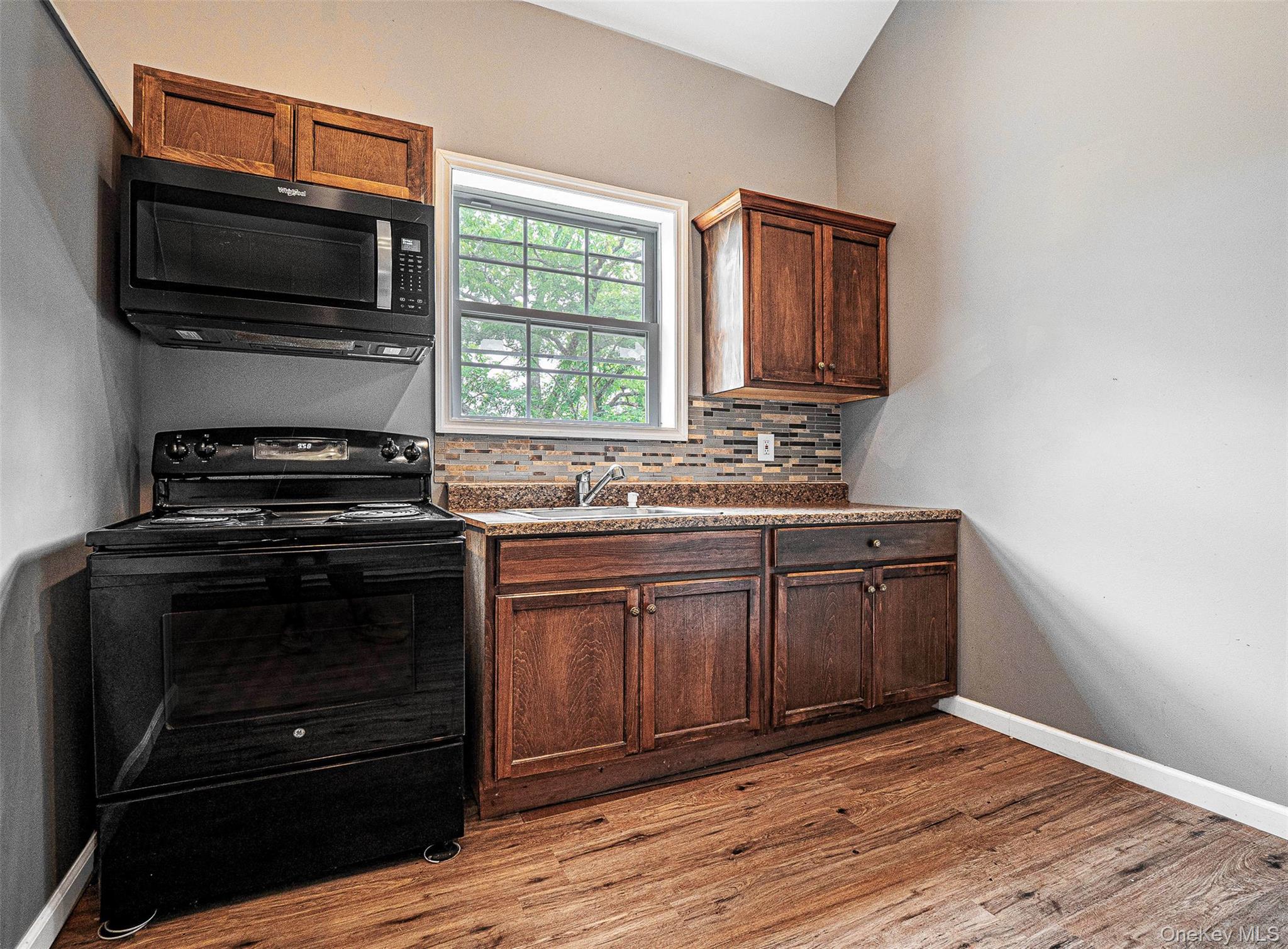 784 County Rte 12 New Hampton, NY 10958 - Photo 10 of 19 a kitchen with granite countertop a stove microwave and wooden floor