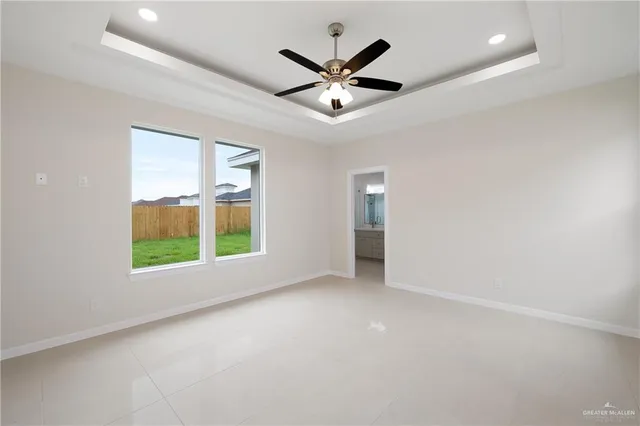an empty room with window and ceiling fan
