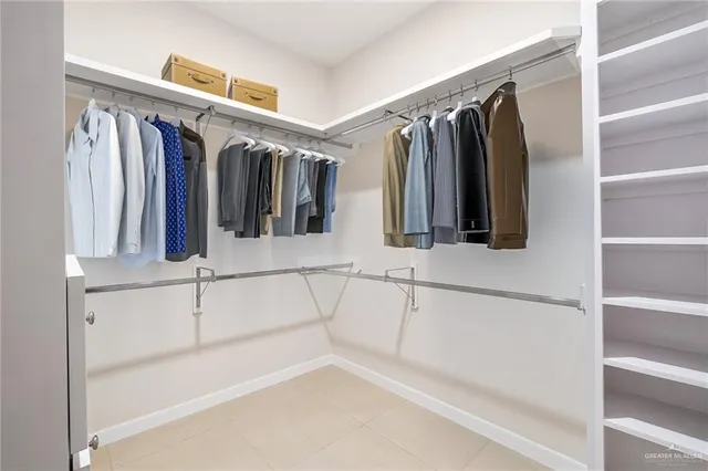 a view of walk in closet with clothes and shoes