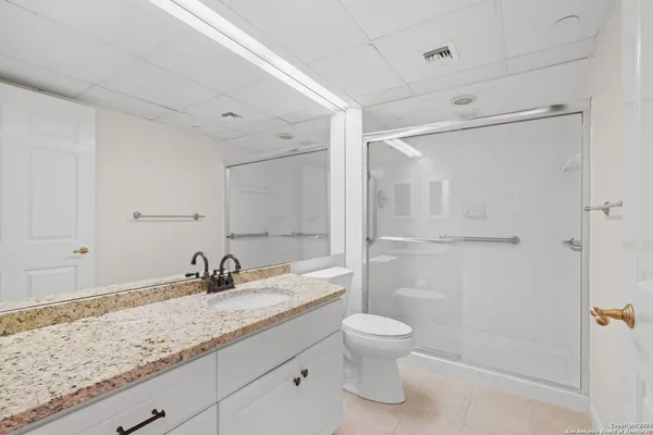a bathroom with a granite countertop sink toilet and shower
