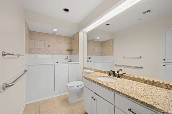 a spacious bathroom with a granite countertop sink mirror and toilet