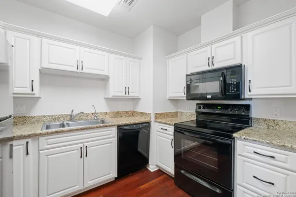 a kitchen with cabinets stainless steel appliances a sink and a counter space