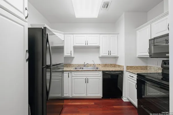 a kitchen with stainless steel appliances granite countertop a stove and a refrigerator