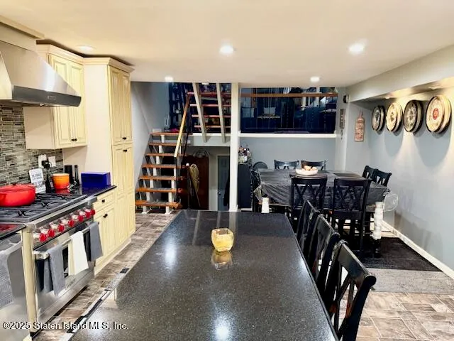 a kitchen with stainless steel appliances a dining table chairs and a refrigerator
