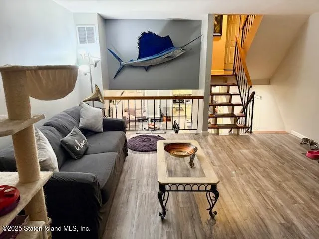 a living room with furniture and a wooden floor