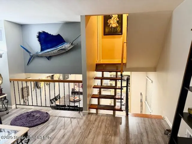 a view of a bedroom with wooden floor and a window