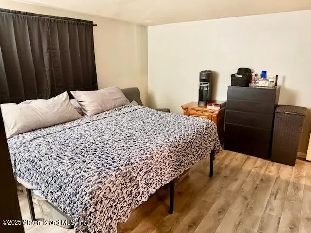 a bedroom with bed and wooden floor