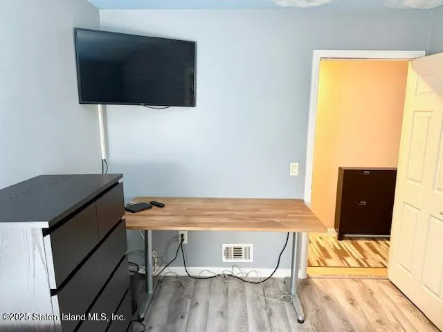 a view of a room with wooden floor and a flat screen tv