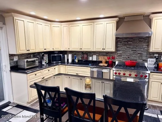 a kitchen with stainless steel appliances granite countertop a stove a sink and white cabinets