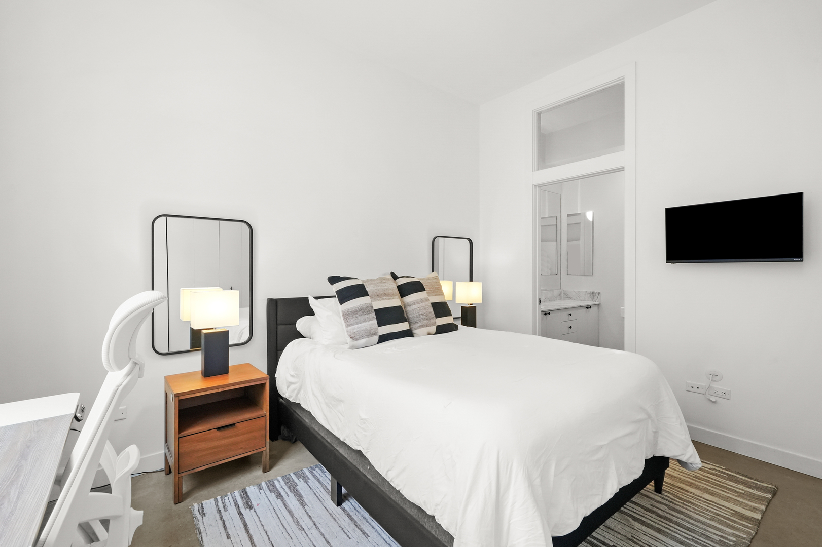 949 West Madison Street, Unit 207 Chicago, IL 60607 - Photo 21 of 31 a bedroom with a bed and a flat tv screen on dresser