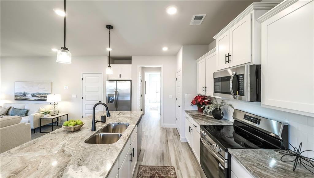 213 Laney Drive Carrollton, GA 30117 - Photo 2 of 36 a kitchen that has a lot of cabinets a sink and appliances in it