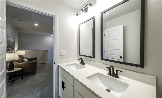 a bathroom with double vanity sinks and a mirror