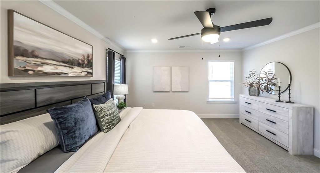 213 Laney Drive Carrollton, GA 30117 - Photo 27 of 36 a bedroom with a large bed and a chandelier