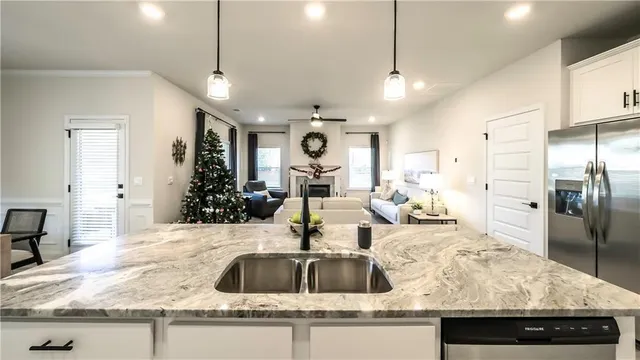 a kitchen with kitchen island granite countertop a sink and refrigerator