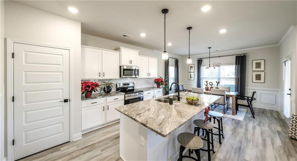 213 Laney Drive Carrollton, GA 30117 - Photo 4 of 36 a kitchen with sink cabinets dining table and chairs