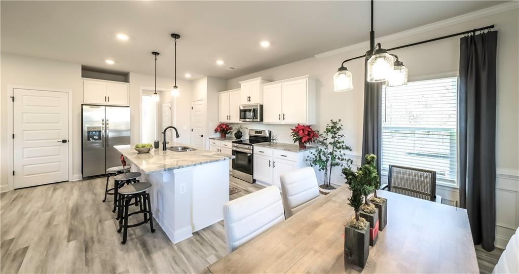 213 Laney Drive Carrollton, GA 30117 - Photo 5 of 36 a kitchen with a table chairs refrigerator and microwave