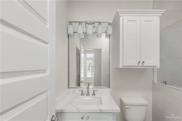 a bathroom with a sink a toilet and shower