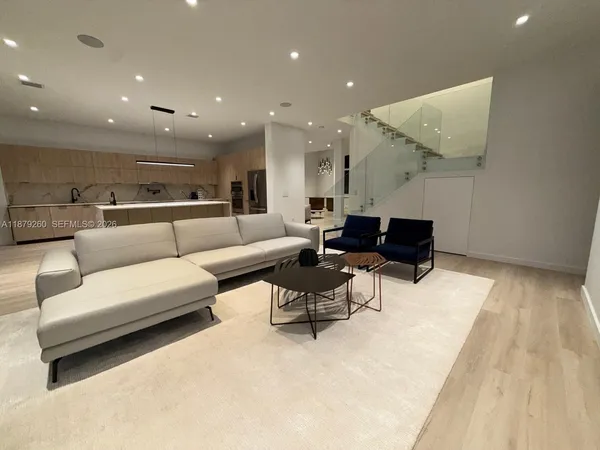 a living room with furniture and a wooden floor
