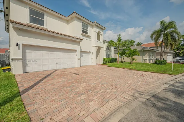 front view of a house with a yard and a garage