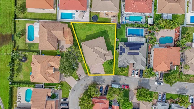 an aerial view of a house with a yard and lake view