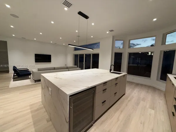 a large kitchen with stainless steel appliances kitchen island a large counter top a sink and a fireplace