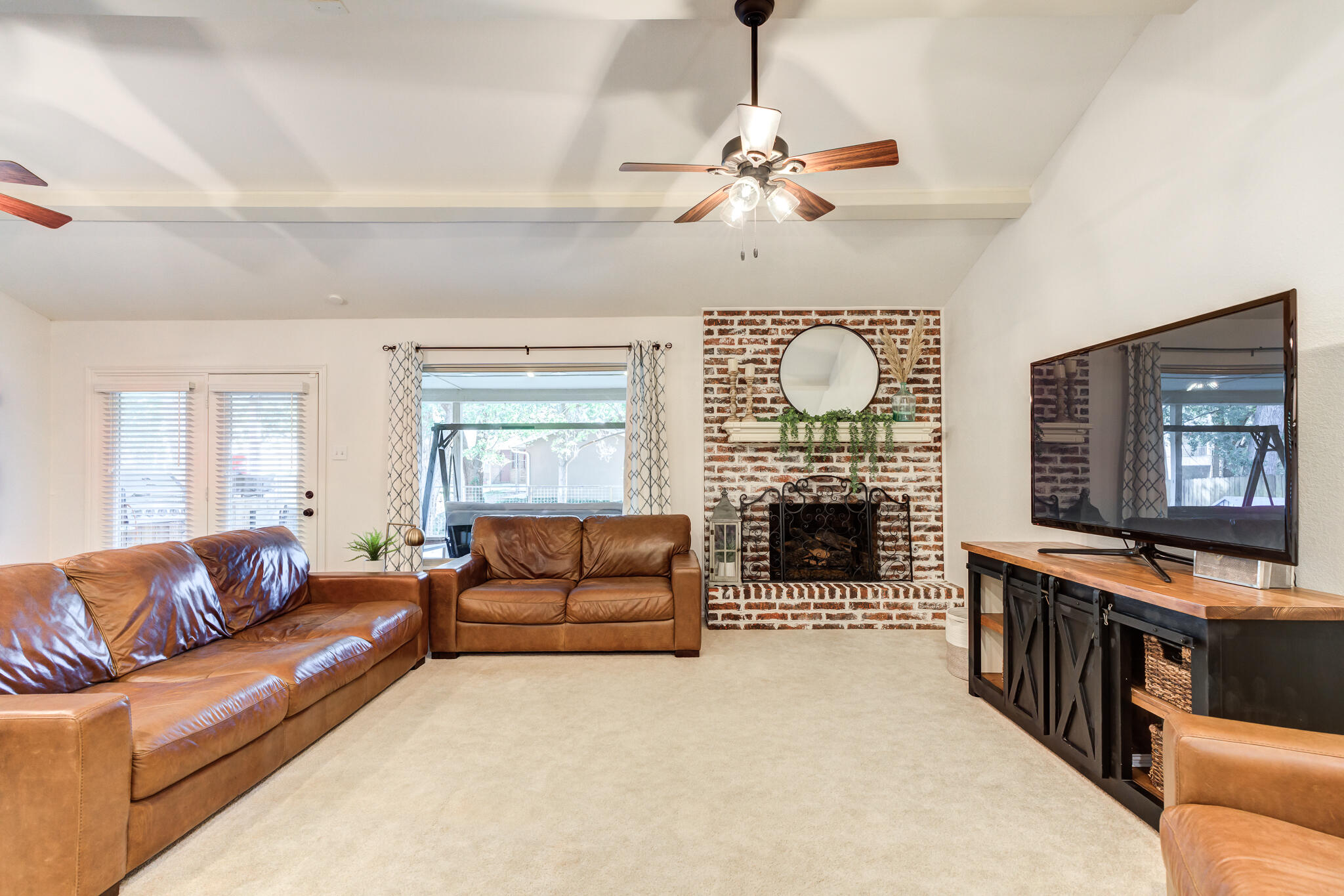 5 West Brookhollow Ransom Canyon, TX 79366 - Photo 13 of 62 a living room with furniture a fireplace and a flat screen tv