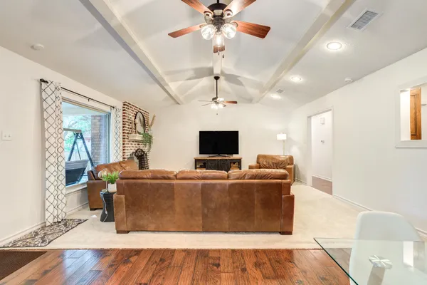 a living room with furniture ceiling fan and a window