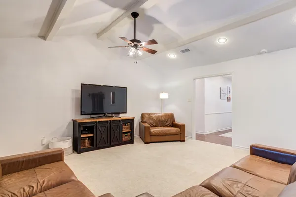 a living room with furniture ceiling fan and a window