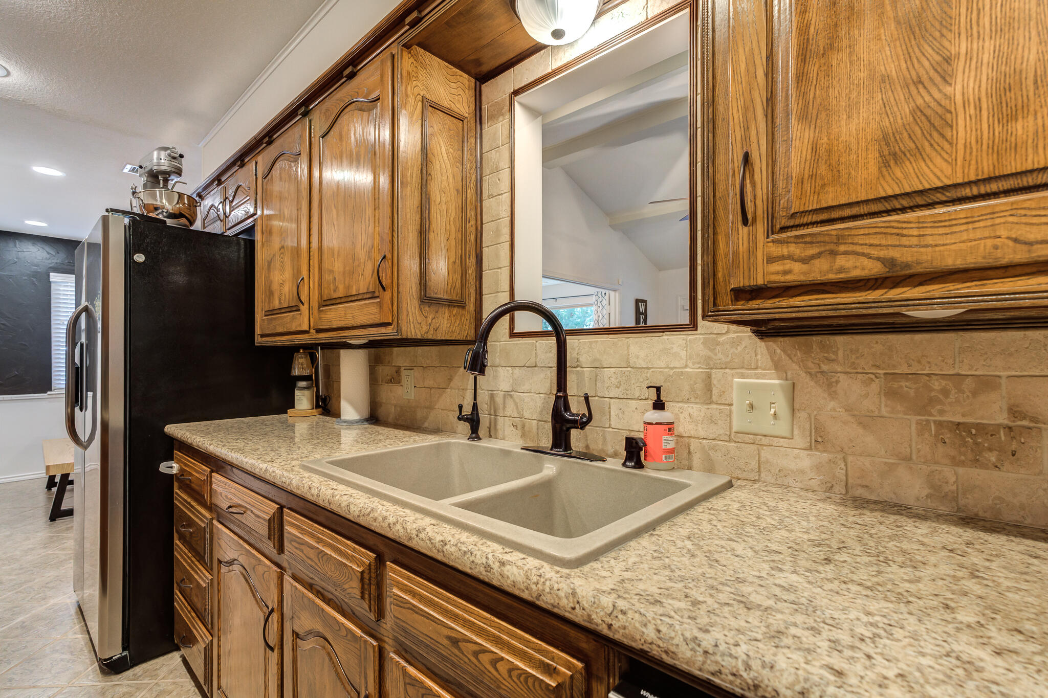 5 West Brookhollow Ransom Canyon, TX 79366 - Photo 37 of 62 a kitchen with granite countertop a sink and a refrigerator