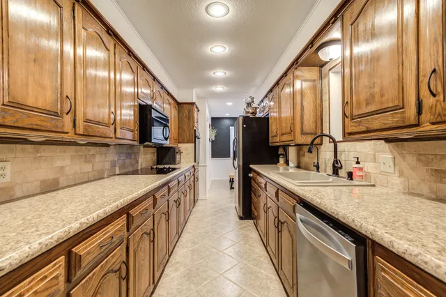 a view of a hallway with wooden floor and a bathroom