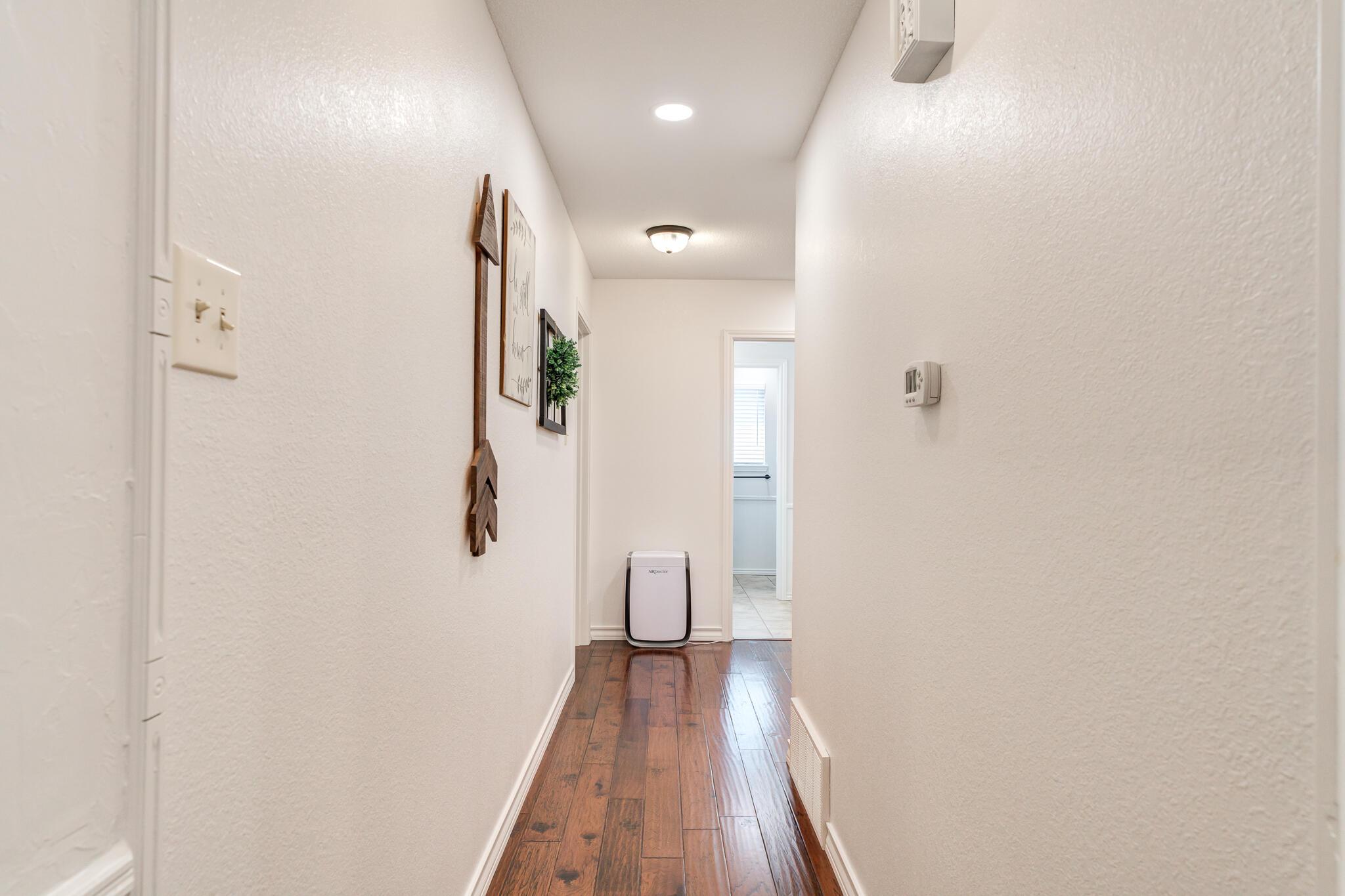 5 West Brookhollow Ransom Canyon, TX 79366 - Photo 47 of 62 a view of a hallway with wooden floor and a bathroom