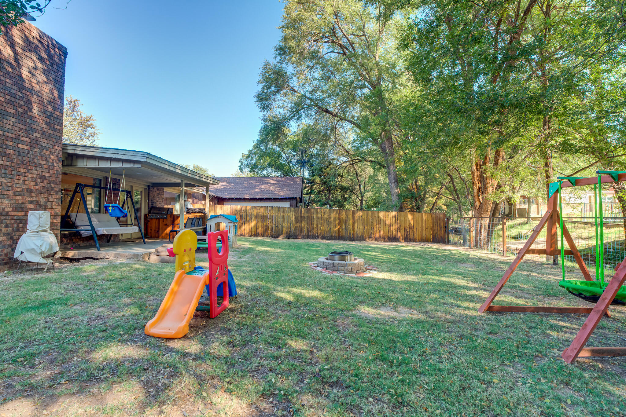 5 West Brookhollow Ransom Canyon, TX 79366 - Photo 57 of 62 a view of a backyard with a slide and a child swing
