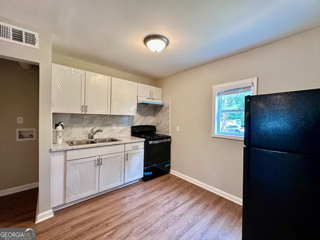 a kitchen with a refrigerator and a stove top oven