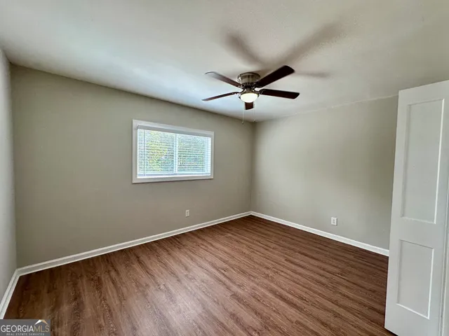 a view of a big room with wooden floor and windows