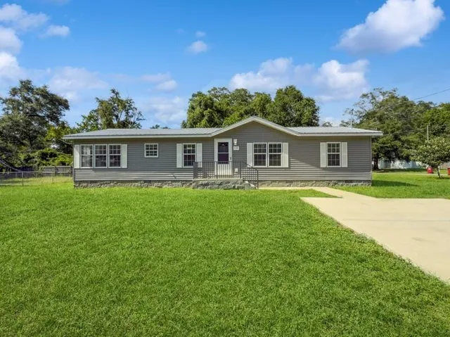 a front view of a house with a yard table and chairs