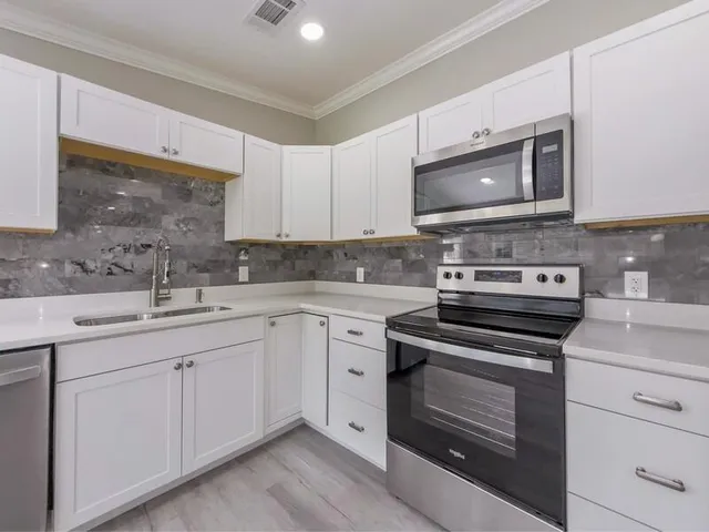 a kitchen with cabinets appliances and a sink