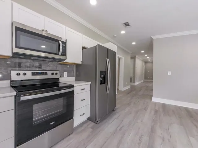 a kitchen with stainless steel appliances a stove microwave and refrigerator