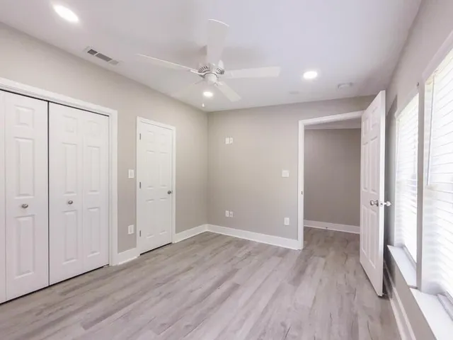 an empty room with wooden floor and windows
