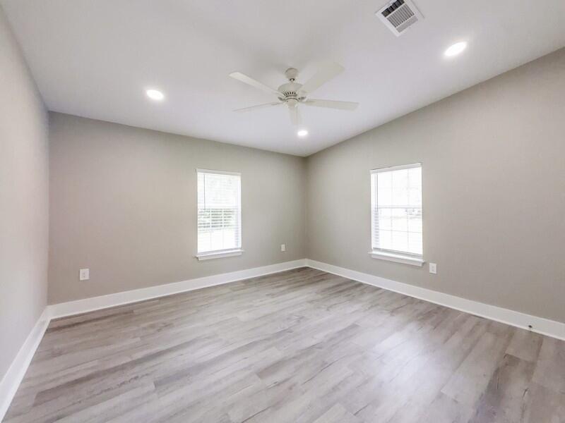 630 West Griffith Avenue Crestview, FL 32536 - Photo 27 of 36 an empty room with wooden floor and windows