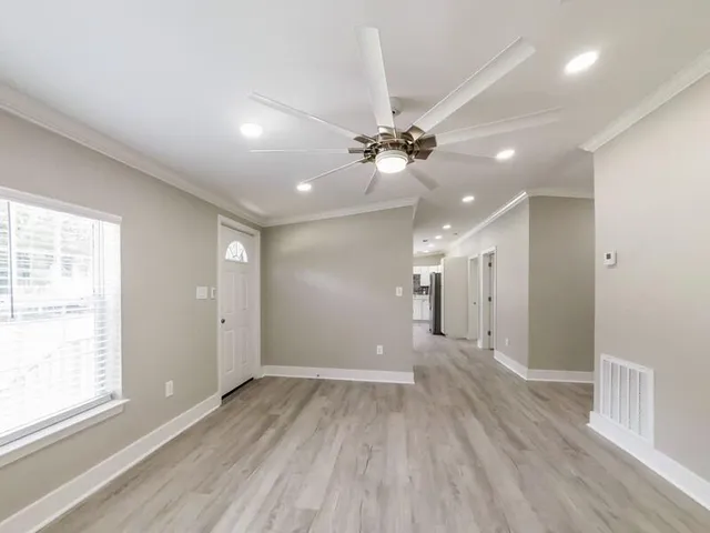 a view of a big room with wooden floor and windows in a room