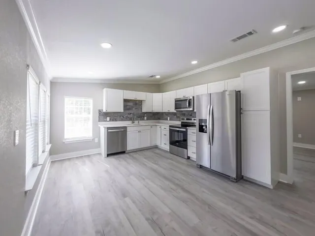 a kitchen with a refrigerator a sink a stove a microwave and cabinets