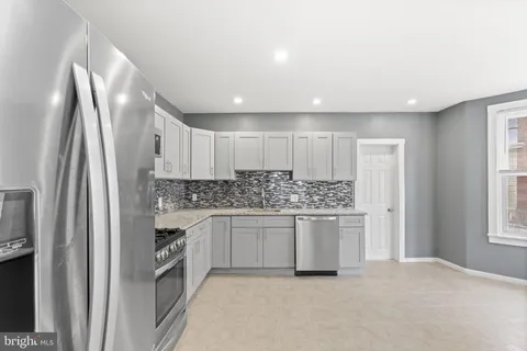 a kitchen with stainless steel appliances granite countertop a refrigerator and a sink