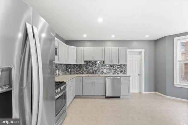 a kitchen with stainless steel appliances granite countertop a refrigerator and a sink