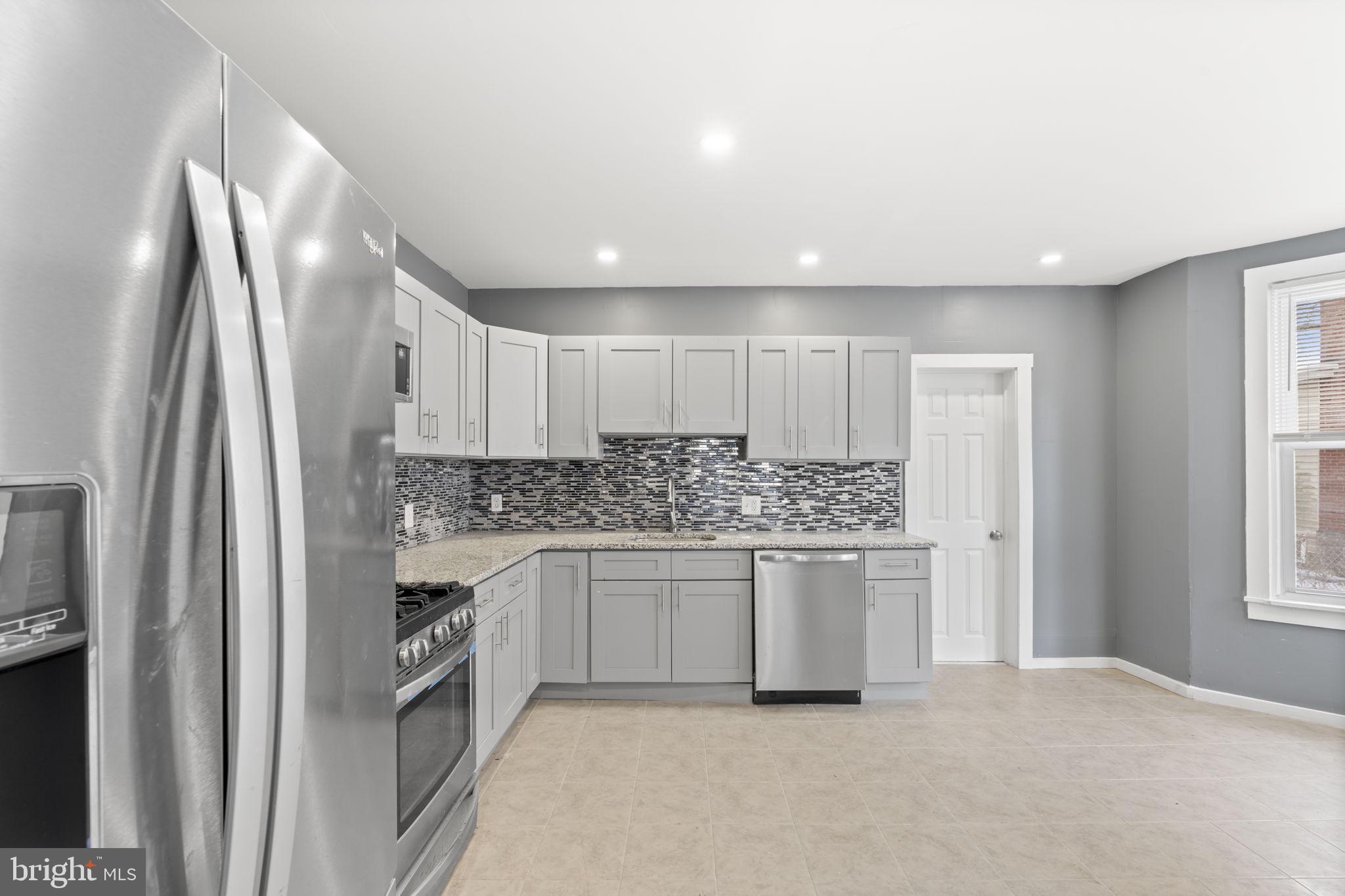 a kitchen with stainless steel appliances granite countertop a refrigerator and a sink
