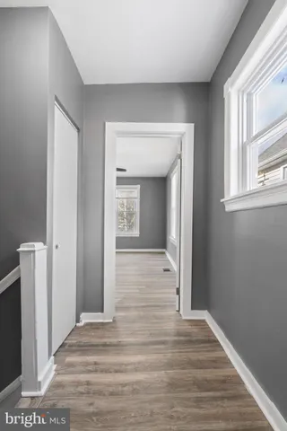 a view of a hallway with wooden floor and closet