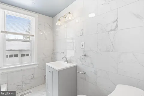 a bathroom with a sink mirror and a shower